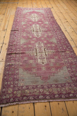 Distressed vintage Oushak runner fringe and border with faded aubergine and slate tones.