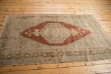 Distressed Oushak rug corner detail, highlighting geometric medallion and border pattern.