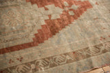 Distressed Oushak rug texture with muted rust stepped geometric and stylized antique ivory border.