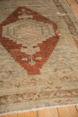 Distressed vintage Oushak rug with soft ivory fringe and faded geometric border.
