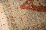 Distressed Oushak rug border showing rust, silver, and ivory tones with fringe.