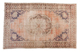 Distressed Oushak carpet with dusty rose medallion and faded blue details, 5'3