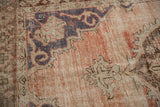 Textured detail of distressed Oushak rug, showing knot heads and faded dusty rose.