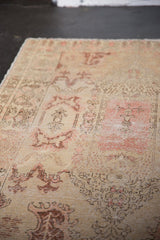 Distressed Oushak rug showing Rococo stylized motifs and worn pile texture.