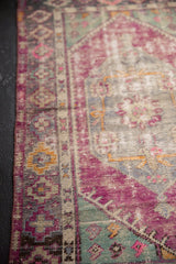 Vintage distressed Oushak rug's aubergine border and mint green spandrel with worn pile.