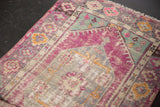 Distressed vintage Oushak rug with vibrant pink, mint green, and grey patterns.