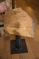 Textured live edge wood tabletop above the dark square iron base.