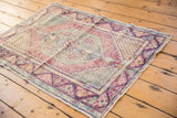 Distressed Oushak rug displaying oversized diamond medallion, visible wear, and blush, wine, sea foam hues.