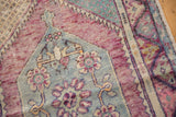 Distressed Oushak rug detail: muted blue medallion with blush florals, dusty wine red field.