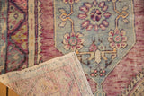 Vintage Oushak rug corner, showing reverse foundation and distressed floral design.