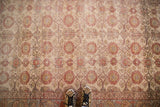 Sivas hand knotted rug's distressed allover floral design in sand, brick red, and blush.