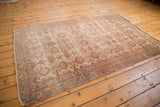 Distressed Sivas rug showing mostly even wear with faded sand and brick red floral motif.