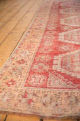 Raspberry red and peach apricot pattern detail on a distressed Oushak runner's low pile.