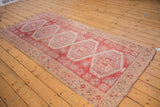 Distressed raspberry red and antique ivory geometric border on a vintage Oushak runner.