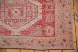 Distressed Oushak runner corner, showing raspberry red serrated motifs and peach apricot border.
