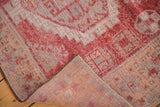 Vintage distressed Oushak rug's textured pile with raspberry, ivory, peach tones and hand-knotted reverse.