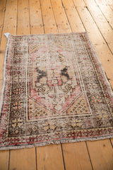 Distressed Oushak rug's secured fringe, highlighting faded red and brown border wear.
