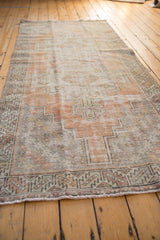 Distressed texture of geometric contour and faded floral motifs in dusty tangerine and silver.