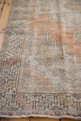Faded geometric border and worn field texture in dusty tangerine and silver.