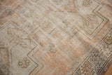 Distressed Oushak rug with mostly even wear to knot heads, faded tangerine, silver, and ivory geometric floral motifs.