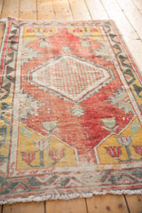 Decorative distressed Oushak runner pile with faded red, yellow, and checkered motif.