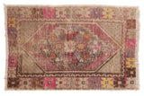 Vintage Distressed Oushak rug featuring a faded mauve diamond medallion with hot raspberry and blue.