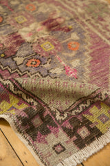 Distressed Turkish Oushak rug's folded pile, showing vivid mauve, raspberry pink, and brown tones.