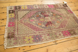 Hot pink and brown geometric patterns on the secured side of the distressed Oushak rug.