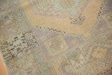 Distressed Oushak rug showcasing storied low pile, lemon sand, and pale blue hues.