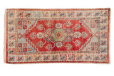 Decorative distressed Oushak rug runner in red, light blue, and ivory with floral motifs.