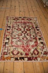 Angled view of distressed Oushak runner, highlighting its floral medallion and meandering vine border.