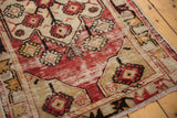 Distressed cherry red field, beige border, and soft pile wear on a vintage Oushak rug.