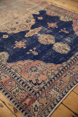 Distressed navy blue field with playful floral motifs, blush border, and even wear.