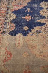 Distressed Sivas rug with heavy navy to silver abrash, worn pile, floral motifs, and visible foundation.
