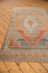 Distressed Oushak rug with blush rust, silver, and dusty aubergine geometric patterns.