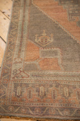 Vintage Oushak runner close-up: evenly worn pile, pale blush rust and dusty aubergine motifs.