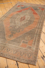 Distressed Oushak runner, pale blush rust border with geometric field motifs.
