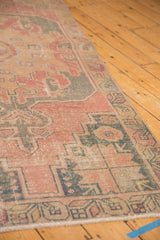 Distressed texture and low pile on a dusty rose and charcoal vintage Oushak rug border.
