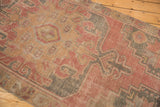 Vintage Distressed Oushak rug runner's low pile with dusty rose, charcoal, and ivory patterns.