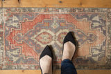 Distressed vintage Oushak mat featuring a textured pile, faded blush, silver, and ivory tones.