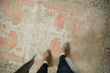 Distressed vintage Oushak rug with time-softened blush, beige, and charcoal tones, highlighting pile wear.