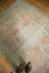 Textured view of a vintage distressed Oushak rug in blush, beige, and time-softened silver.