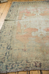 Decorator-friendly distressed vintage Oushak rug's softened pile with blush, silver, and charcoal tones.