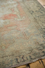 Distressed Oushak rug's textured pile in blush, sand, and charcoal with corner finial.