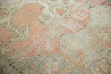 Distressed vintage Oushak rug close-up, revealing faded blush, sand, and gray pile.