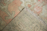 Worn blush pile, soft fringe, and hand-knotted foundation of a vintage Oushak rug.