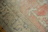 Distressed Oushak rug texture showing wear to pile and foundation in blush, beige, charcoal.