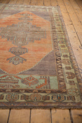 Distressed Oushak runner with geometric tangerine, pale green border and short fringe.