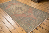 Distressed Oushak runner with worn pile, pale blush, silver, and muted green.