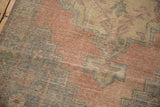 Distressed Oushak runner's worn pile revealing pale blush, aqua, green geometric motifs.